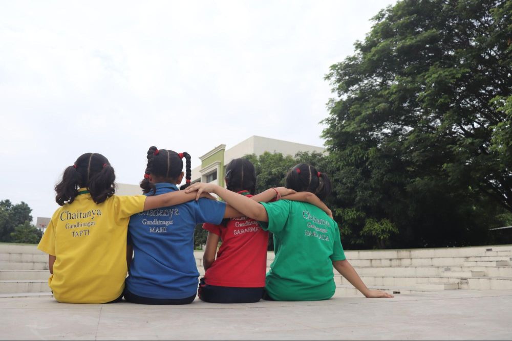 
Back-view of students bonding outdoors at Chaitanya School, the Best CBSE School in Gandhinagar.